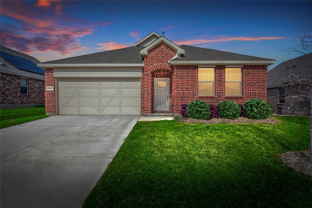 view of front of house with a garage and a yard