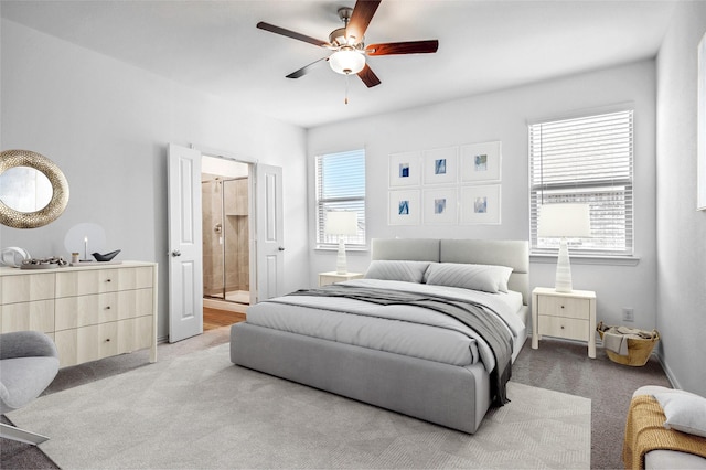 carpeted bedroom featuring ensuite bath and ceiling fan