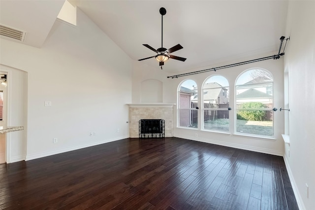 unfurnished living room featuring a tile fireplace, high vaulted ceiling, ceiling fan, and dark hardwood / wood-style flooring