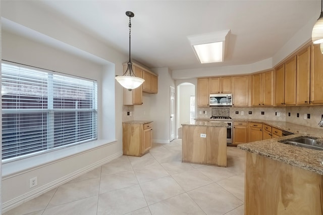 kitchen with sink, tasteful backsplash, decorative light fixtures, a center island, and appliances with stainless steel finishes