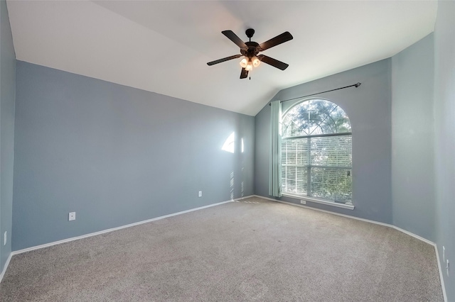 carpeted spare room with ceiling fan and vaulted ceiling