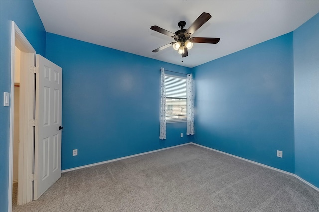 carpeted empty room featuring ceiling fan