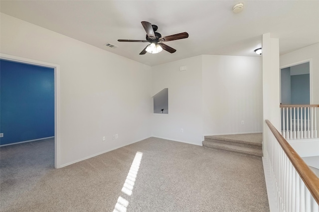 spare room with ceiling fan and light carpet