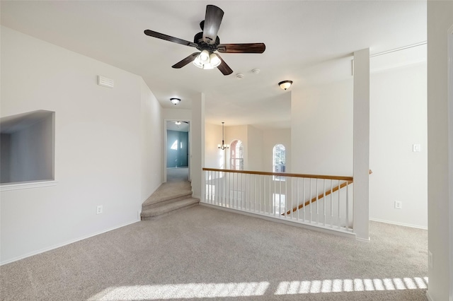 spare room featuring light carpet and a notable chandelier