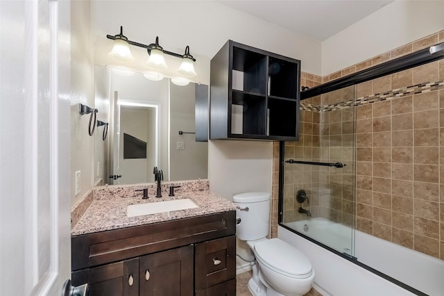 full bathroom with enclosed tub / shower combo, vanity, and toilet