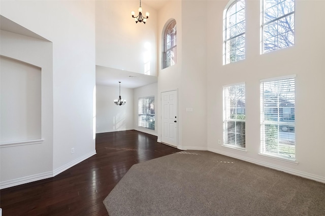 foyer featuring dark hardwood / wood-style flooring, a high ceiling, and a notable chandelier