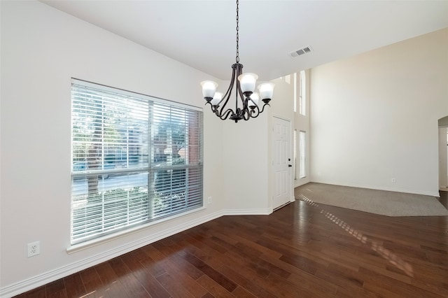 unfurnished dining area featuring dark wood-type flooring and a chandelier