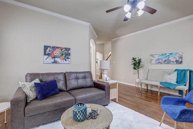 living room with hardwood / wood-style floors, crown molding, and ceiling fan