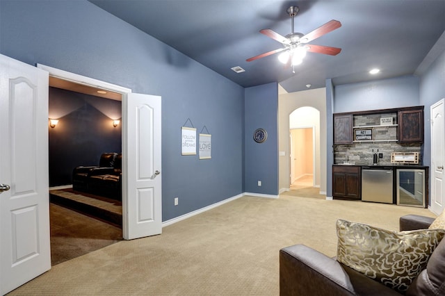 living room with lofted ceiling, indoor bar, light carpet, and wine cooler