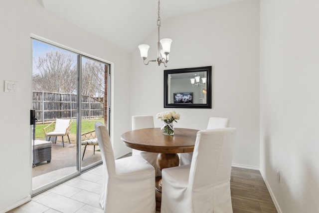 dining area featuring lofted ceiling, a chandelier, and light hardwood / wood-style flooring