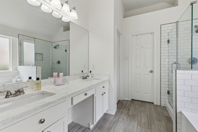 bathroom featuring a shower with door, vanity, and lofted ceiling