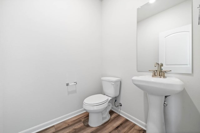 bathroom with toilet and hardwood / wood-style floors