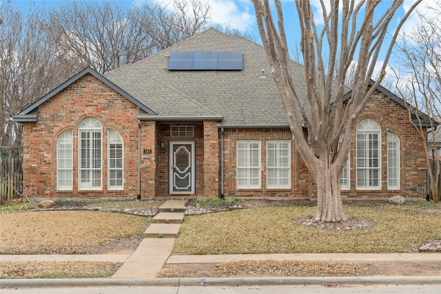 view of property with a front lawn and solar panels