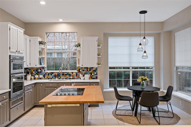 kitchen featuring white cabinetry, decorative light fixtures, a kitchen island, and gray cabinetry