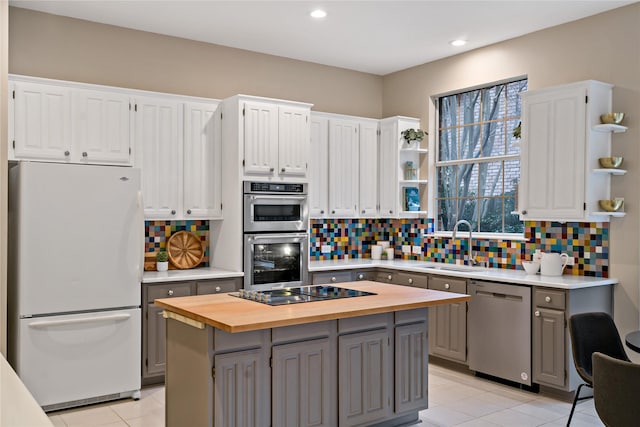 kitchen featuring gray cabinetry, white cabinetry, stainless steel appliances, and a center island