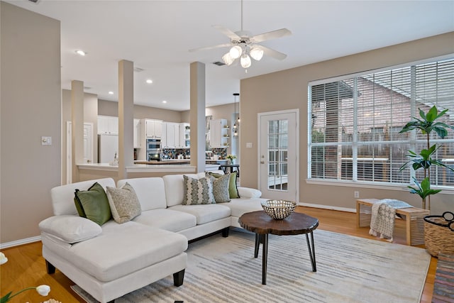 living room featuring ceiling fan and light hardwood / wood-style flooring