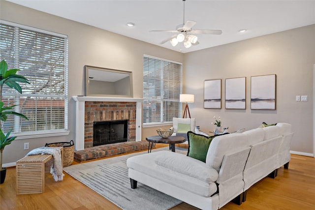 living room featuring hardwood / wood-style floors, a fireplace, and ceiling fan