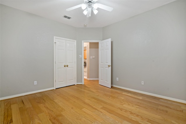 unfurnished bedroom with washer / dryer, a closet, ceiling fan, and light wood-type flooring