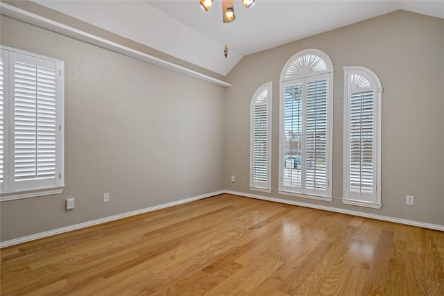 empty room with vaulted ceiling and light hardwood / wood-style floors