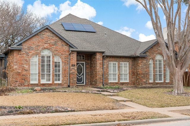 view of front property with a front lawn and solar panels