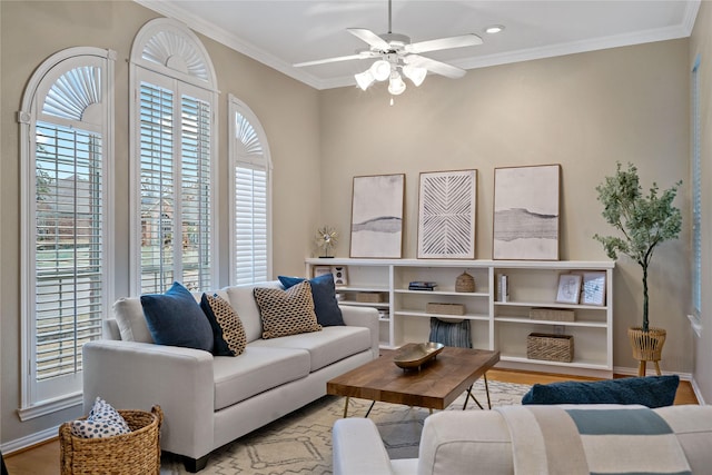 living room with crown molding, light wood-type flooring, and ceiling fan