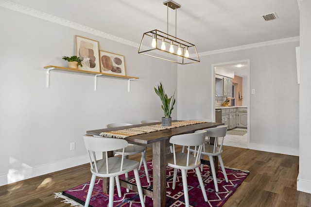 dining room with crown molding and dark hardwood / wood-style floors