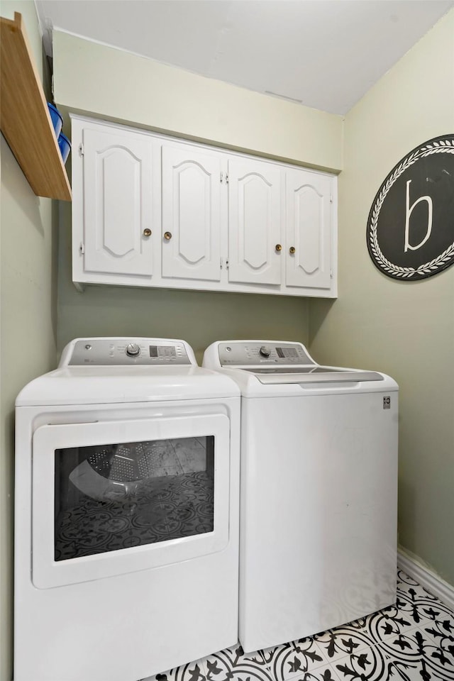 laundry room featuring cabinets and washer and clothes dryer