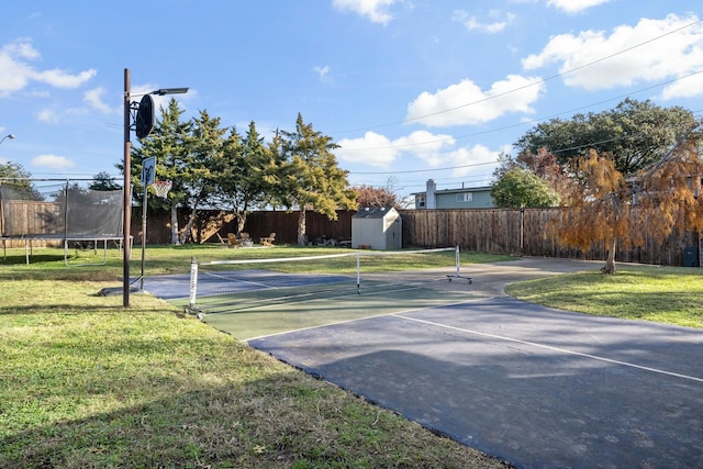 exterior space with tennis court and a lawn