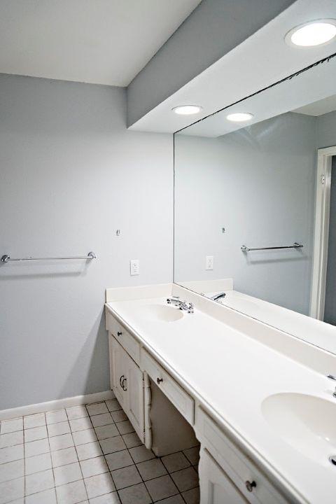 full bath with double vanity, tile patterned flooring, baseboards, and a sink