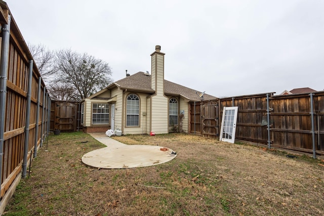 rear view of house with a lawn and a patio