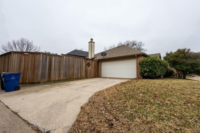 view of side of property with a garage and a lawn