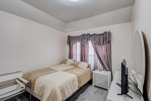 bedroom with hardwood / wood-style flooring and a textured ceiling