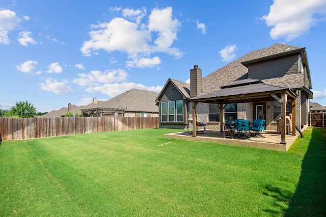 rear view of house with a gazebo, a yard, and a patio