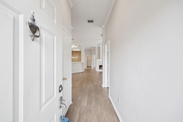 corridor featuring crown molding and light hardwood / wood-style floors