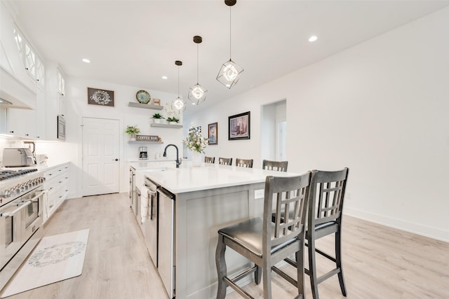 327 Lovers Ln, Terrell, TX 75160 - kitchen with open shelves, appliances with stainless steel finishes, a breakfast bar, and light wood-type flooring
