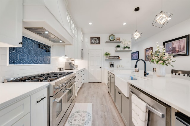 327 Lovers Ln, Terrell, TX 75160 - kitchen featuring light wood-style floors, custom range hood, a sink, backsplash, and stainless steel appliances