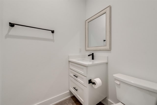 327 Lovers Ln, Terrell, TX 75160 - half bathroom featuring vanity, baseboards, toilet, and wood finished floors
