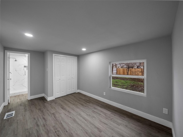 unfurnished bedroom with hardwood / wood-style flooring and a closet