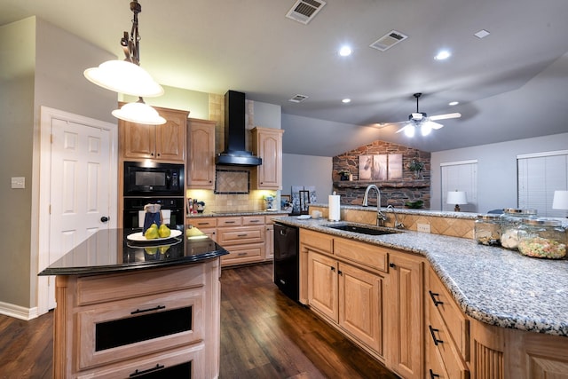 kitchen featuring sink, light stone counters, black appliances, a center island with sink, and wall chimney exhaust hood