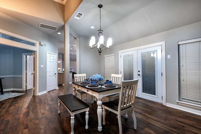 dining room featuring french doors, dark hardwood / wood-style floors, a chandelier, and vaulted ceiling