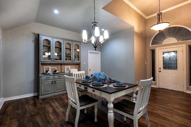 dining space with crown molding, lofted ceiling, a notable chandelier, and dark hardwood / wood-style flooring