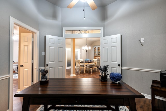 office space with wood-type flooring and ceiling fan with notable chandelier