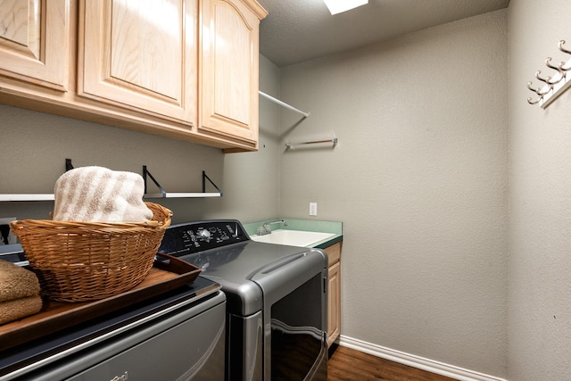 laundry room with cabinets, sink, dark wood-type flooring, and independent washer and dryer