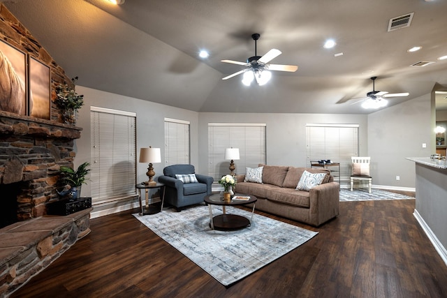 living room featuring lofted ceiling, dark hardwood / wood-style floors, a stone fireplace, and ceiling fan