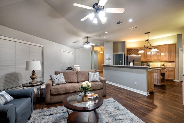 living room featuring dark wood-type flooring, vaulted ceiling, and ceiling fan