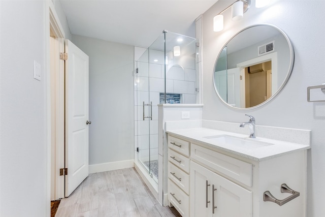 bathroom featuring vanity and a shower with door