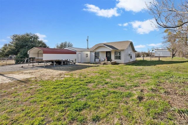 back of house featuring fence, a carport, and a yard