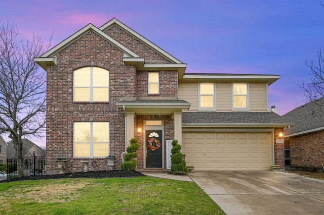 traditional-style home featuring brick siding, a shingled roof, a lawn, driveway, and an attached garage