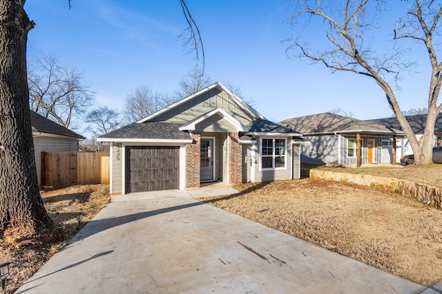 view of front of property with brick siding, concrete driveway, a garage, and fence