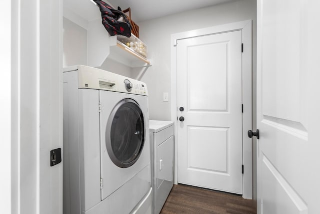 laundry area featuring washer and dryer and dark wood-type flooring